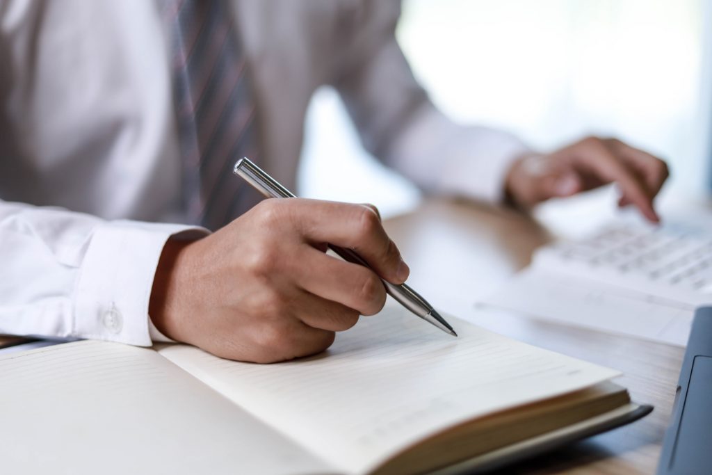 Business Man Is Taking A Note Of Work To Reminders In His Appointment Book, He Takes Notes After Every Business Meeting, A Reminder Idea.